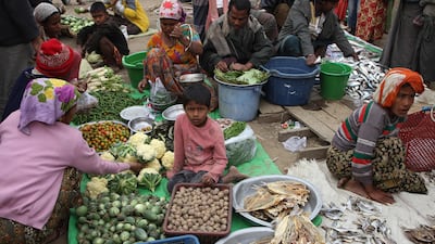 A child looks on as Rohingya vendors sell vegetables at a market at Thet Kal Pyin camp in Rakhine Sate. AFP