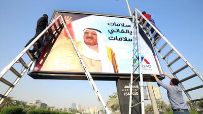 Workers fix install a giant portrait of the emir of Kuwait, Sheikh Sabah al-Ahmad al-Jaber al-Sabah, on a billboard on one of the main roads in Kuwait City on October 16, 2019, to mark his return to the country after a medical trip in the United States. The ruler of Kuwait has been admitted to a hospital in the United States for "medical tests" last month, according to senior officials in the Gulf emirate. The sources did not specify the type of tests the 90-year-old emir was undertaking. / AFP / Yasser Al-Zayyat