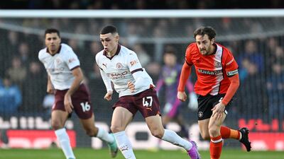 Phil Foden of Manchester City makes a break with Tom Lockyer of Luton Town in pursuit. Getty Images