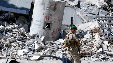A Lebanese soldier walks past the rubble of buildings destroyed by Israeli bombardment in Nabatieh, southern Lebanon. AFP