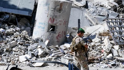 A Lebanese soldier walks past the rubble of buildings destroyed by Israeli bombardment in Nabatieh, southern Lebanon. AFP