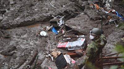 Members of Japan's Self-Defence Forces search for missing people in Atami at the scene of a landslide triggered by days of heavy rain. AFP