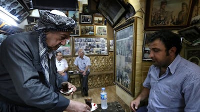 The 96-year-old began collecting them, turning the cafe into a gallery awash with photos that portray Iraq as it moved through monarchy, dictatorship and into its current fragile democracy. Safin Hamed / AFP