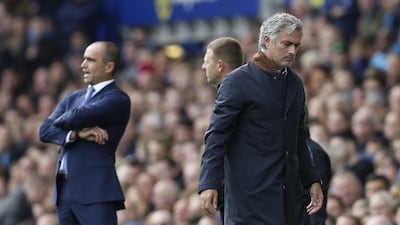 Chelsea manager Jose Mourinho, right, looks dejected as Everton's Roberto Martinez looks on the pitch during their match Saturday. Everton won, 3-1. Reuters / Ed Sykes