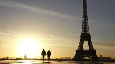 People walk down the Trocadero Esplanade in front of the Eiffel Tower at sunrise in Paris on February 11, 2014. Ludovic Marin / AFP photo