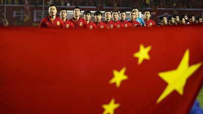 Team China listen to national anthem behind a Chinese national flag ahead of the match. Stringer / Reuters