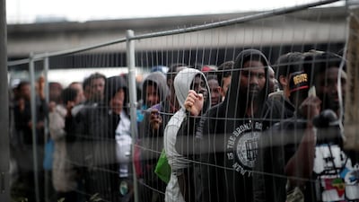 Migrants with their belongings stand in line as French police evacuate hundreds of migrants living in makeshift camps in Paris, France. Benoit Tessier / Reuters