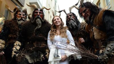 A woman dressed as an angel poses with masked participants prior to the start of the traditional Krampus run, near the Christmas market in Munich, Germany. A Krampus is a horned folklore figure described as half-goat, half-demon. Andreas Gebert / dpa via AP