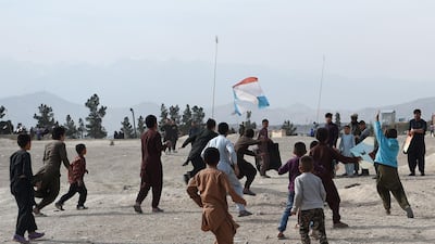 Youths attempt to catch a loose kite after it had its strings cut during a kite battle.
