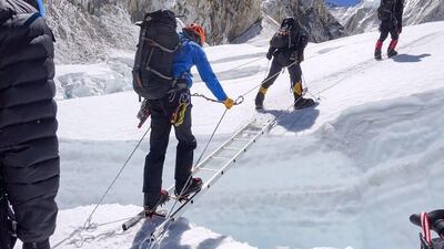 The team of Armed Forces use a ladder to cross a crevasse during a bid to climb Everest.