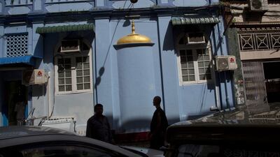 A Buddhist monk, right, and a Muslim man walk past each other in front of a mosque in Yangon, Myanmar. An association of radical Buddhist monks, known by its Myanmar-language acronym Ma Ba Tha, plans to celebrate the passage of “race and religion protection” laws which have been widely criticised as intended to victimise the country’s Muslim minority in predominantly Buddhist Myanmar. Gemunu Amarasinghe / AP