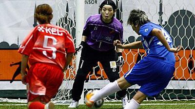 Japan's Nao Kobayashi lines up a shot against the International Golden Group's Moroccan goalkeeper, Elham Hemodi.