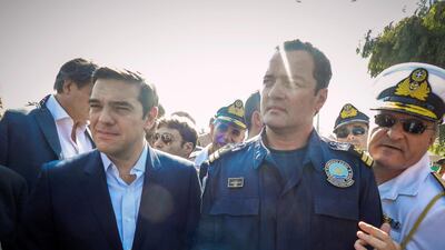 Greek Coast Guard Lieutenant Kyriakos Papadopoulos stands next to Greek Prime Minister Alexis Tsipras during Tsipras's visit to the island of Lesbos in 2015. REUTERS