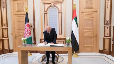 Mr Ghani signs the visitors book during a reception at the Presidential Palace.