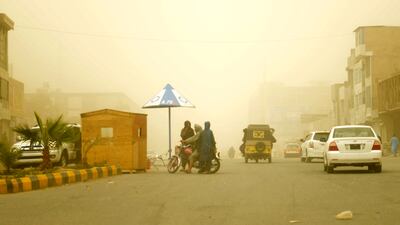 Commuters make their through a dust storm in Kandahar. AFP