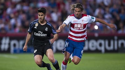 Real Madrid’s Marco Asensio, left, duels for the ball against Granada’s Rene Krhin. Daniel Tejedor / AP Photo