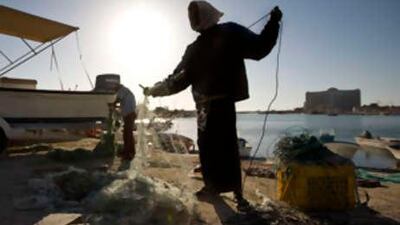 Mohammed Ali, 42, a fisherman, organizes his fishing net near the former dhow ship building yard at Marina Al Bateen.