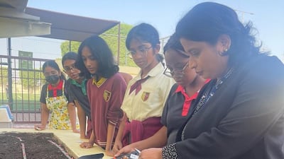 Frithi Francis, right, director of innovation, IT and sustainability at Cambridge High School – Abu Dhabi, with pupils. Photo: Cambridge High School