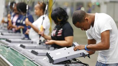 Workers on the assembly line replace the back covers of television sets at Element Electronics in Winnsboro, South Carolina. Element previously made all its TVs in Asia, but the production switch to the US has led to significant savings in ocean freight charges and customs duties on finished goods. Chris Keane / Reuters