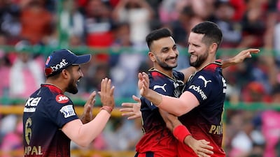 Royal Challengers Bangalore's Wayne Parnell, right, celebrates after claiming the wicket of Rajasthan Royals batter Joe Root in the IPL on May 14, 2023. AP