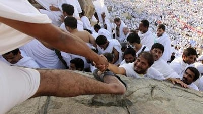 A Muslim pilgrim is helped onto Mount Mercy on the plains of Arafat, outside the holy city of Mecca.