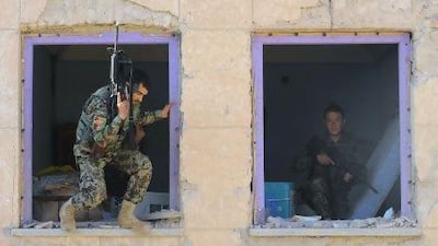 ??Afghan National Army (ANA) soldiers stand in the remains of windows at a court house after a Taliban attack killed 46.