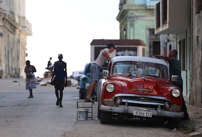 Men wash a vintage car on a street before the Cuban government presents far-reaching economic measures that could mark the most significant shift toward a market economy since the 1959 revolution, in Havana, Cuba June 17, 2026. REUTERS / Norlys Perez