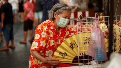 A woman wearing a protective face mask waits for customers in Chinatown. Reuters