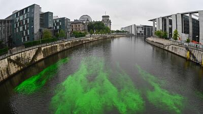 A section of the River Spree next to the Reichstag building, seat of the German lower house of Parliament Bundestag is coloured green by activists from the 'Extinction Rebellion' to protest against the German government's coal policies in Berlin. AFP