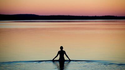 A young woman wades into the shallow waters of the Brombach Lake near Pleinfeld, Bavaria state, Germany, as the sun sets. Daniel Karmann / EPA