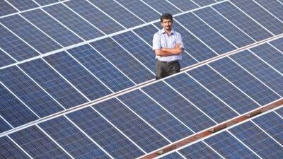 N Yogesh, an Orb Energy technician, with solar panels fitted on a roof in Bangalore. Adeel Halim / Orb Energy