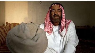 Mohammed Alawi, a resident of Ghalilah, holds a vacuum cleaner bag full of quarry dust.