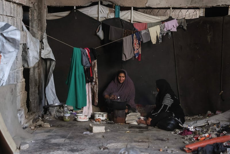 Palestinian women prepare food inside a damaged building at the Jabalia refugee camp in the northern Gaza Strip on October 5. AFP