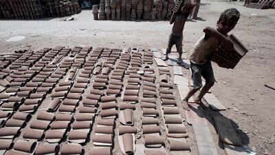 Children sort clay pieces to dry outside one of the traditional pottery workshops in Old Cairo, Egypt.