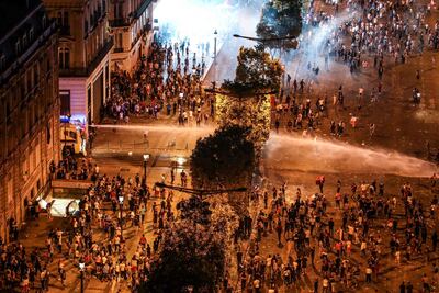 Police fire water cannon after clashes on the Champs Elysees during celebrations of France's World Cup on July 15, 2018. Ludovic Marin / AFP