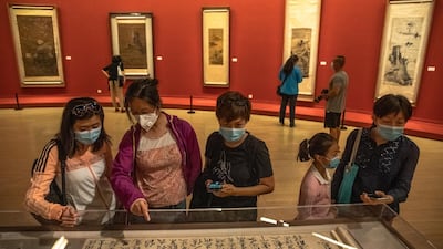 People wearing protective face masks visit 'A tribute to donors' exhibition at the National Art Museum of China on the first day after reopening, in Beijing, China, 13 May 2020. EPA