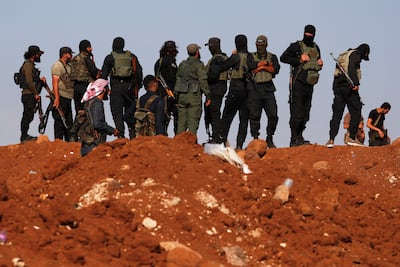 Syrian government security forces gather on a hillside in Busra Al Harir, near Sweida province. AP