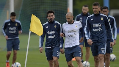 Ezequiel Lavezzi, Javier Mascherano and Martin Demichelis walk during a training session. Juan Mabromata / AFP