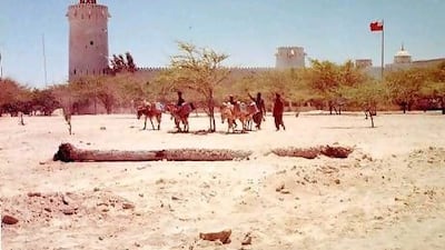 Men drive their donkeys past Qasr Al Hosn. Photo: John Vale