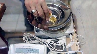 A jeweller checks the weight of 180 grams of 24K gold for a customer in Abu Dhabi.