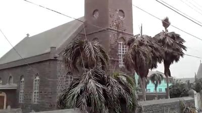 Ash covers palm trees and a church in the town of Georgetown, about eight kilometres from the La Soufriere volcano. Reuters