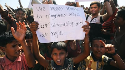 A boy holds a placard as hundreds of Rohingya refugees protest. Reuters