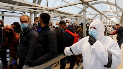A health worker watches as Palestinian labourers head to work in Israel through a checkpoint near Hebron in the Israeli-occupied West Bank. Reuters