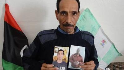 Fathi Ali Ibrahim shows photos of his missing brothers Ibrahim Ali Ibrahim and Mahmoud Ali Ibrahim in his home in Tripoli. Their disappearance shines a light on a city where toothless police only direct traffic and such law as there is comes from the AK-47s of warring militias.