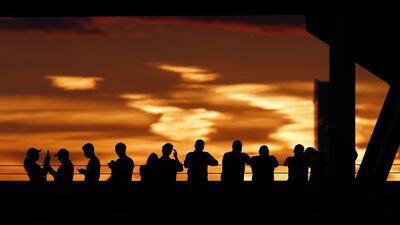 Spectators at the top of Arthur Ashe Stadium take in the sunset as Novak Djokovic, of Serbia, and Stan Wawrinka, of Switzerland, play during a semifinal match at the US Open tennis tournament in New York. Julio Cortez / AP Photo