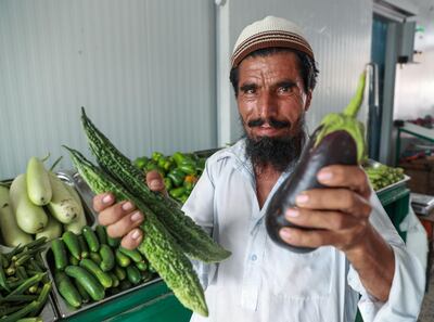 Sher Khan, 45, shows off his fresh vegetables at Dar Al Dhiyafa, a produce shop at the Mina Zayed fruit and vegetable market. Victor Besa / The National