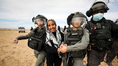 A Bedouin woman is detained by Israeli security forces during a protest against forestation in the Negev desert village of Sawe Al Atrash, southern Israel, on January 12, 2022. Reuters