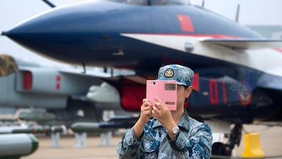 A soldier of the People's Liberation Army Air Force (PLAAF) takes a selfie in front of a J-10 jet fighter ahead of the Airshow China 2014 in Zhuhai, south China's Guangdong province on November 10, 2014. Johnnes Eisele / AFP