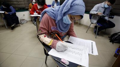 Palestinian English programme students wear protective face masks as they take an end-of-year exam at their school in the occupied Gaza City. AFP