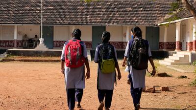 Indian students in uniform clothing arrive at a government-run junior school in Udupi, Karnataka state, India. AP